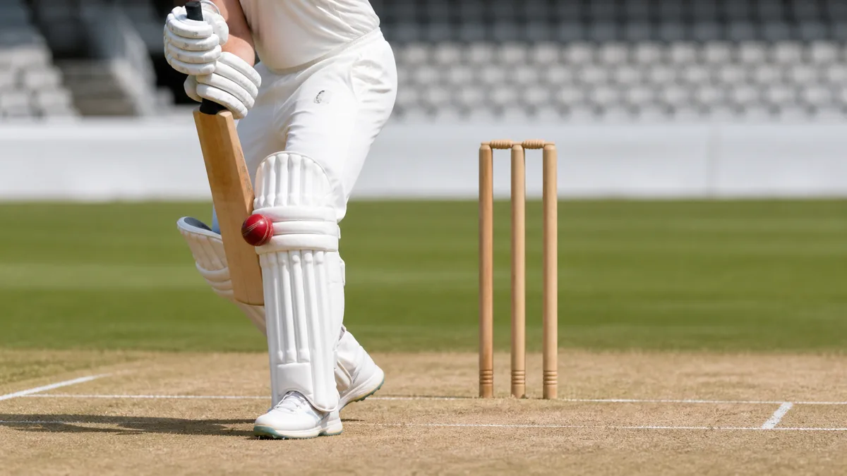 Red cricket ball striking a batter's front pad in line with the stumps